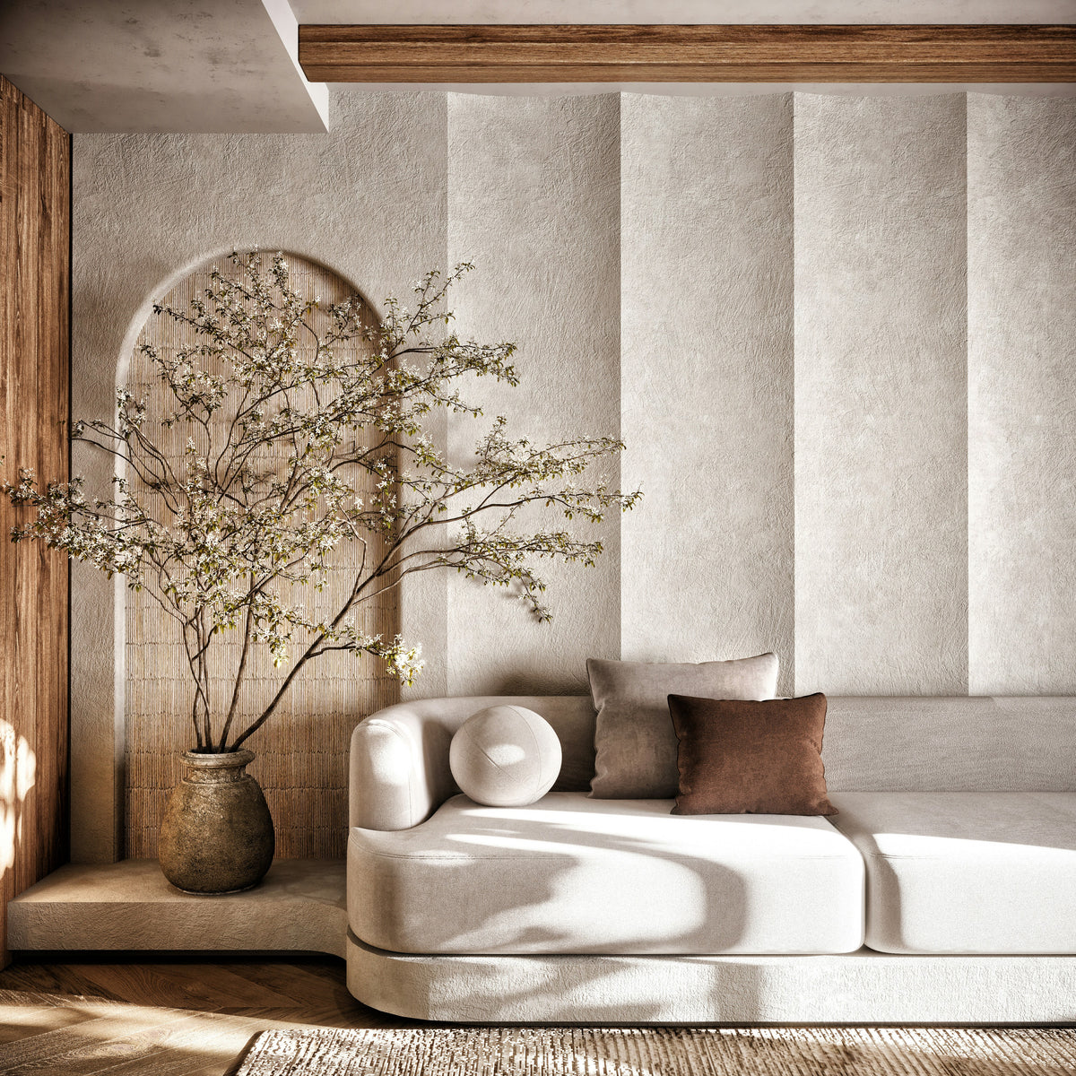 Modern living room with a white sofa, decorative pillows, and a vase with branches.