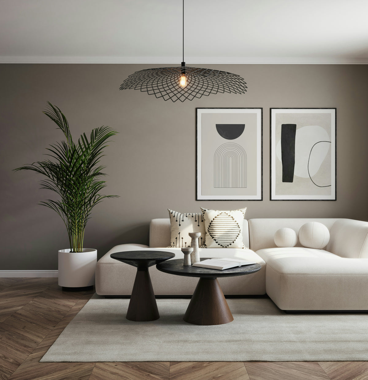 Modern living room with a white sofa, black tables, and abstract art on the wall.